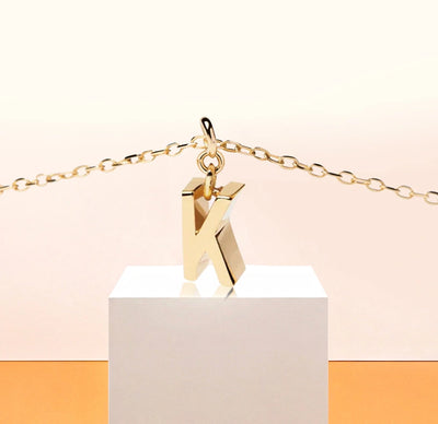 Elegant initial K necklace in 18K gold-plated brass with a 9mm x 3mm pendant, designed for timeless, personalized style.