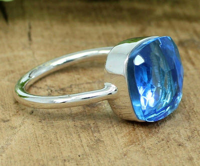 Sterling silver stackable ring featuring a vibrant blue topaz hydro gemstone with cushion-cut brilliance