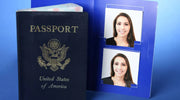 A U.S. passport placed beside a blue folder containing two identical passport-sized photos of a smiling woman with straight brown hair, wearing a black top.