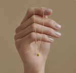 Citrine November birthstone necklace featuring a brilliant-cut golden gemstone set in 14K gold-plated pendant on an adjustable chain.
