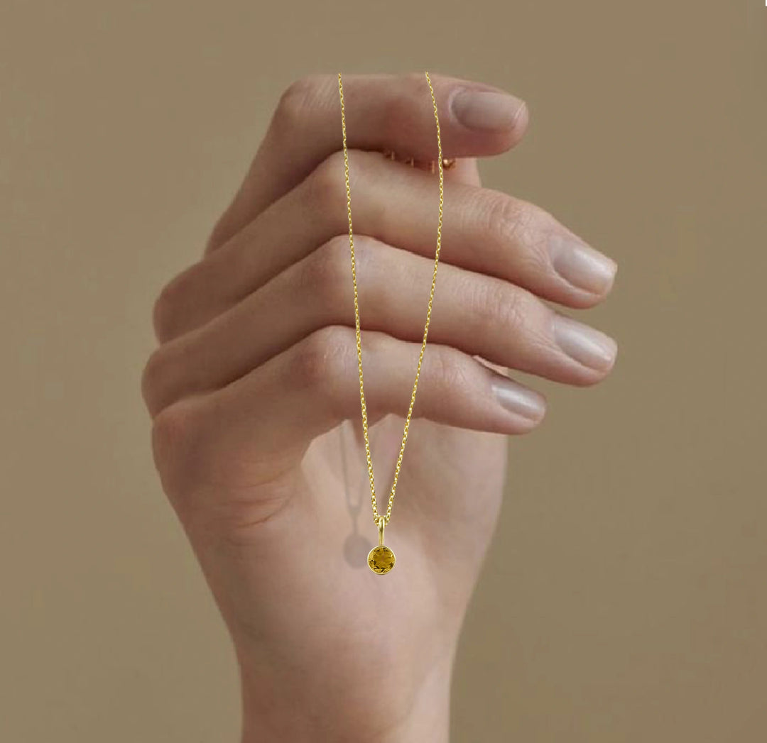 Citrine November birthstone necklace featuring a brilliant-cut golden gemstone set in 14K gold-plated pendant on an adjustable chain.
