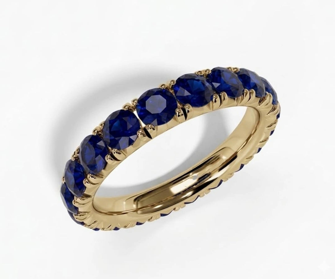 Round cut lab blue sapphire full eternity band ring with continuous sparkling blue stones in a sleek silver setting