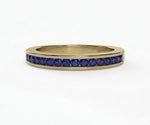 Delicate blue sapphire ring featuring round cut stones in a half eternity band design for timeless sparkle
