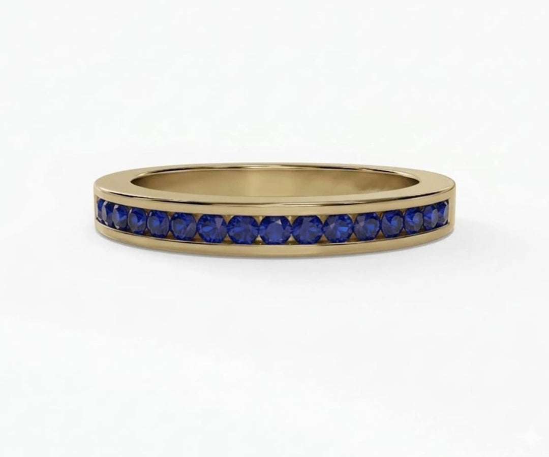 Delicate blue sapphire ring featuring round cut stones in a half eternity band design for timeless sparkle