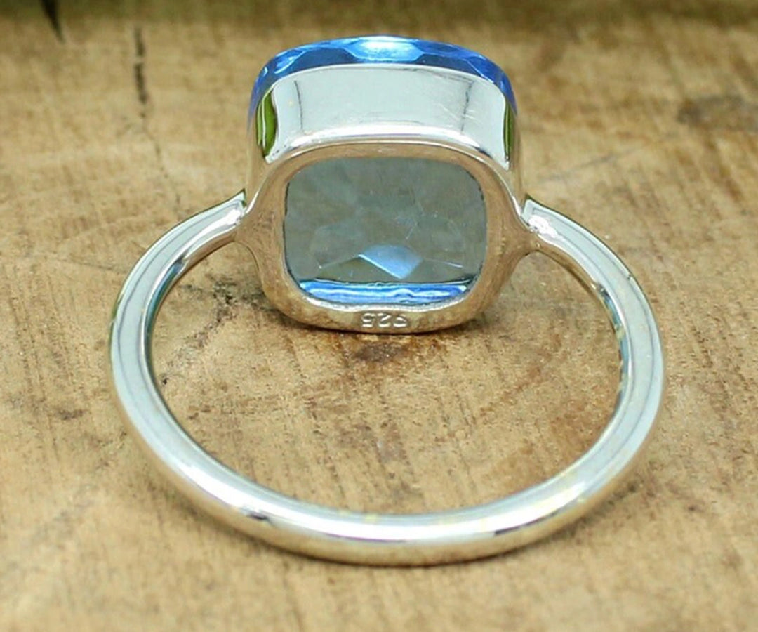 Eye-catching blue topaz ring with a bold cushion-cut stone, ideal for stacking and everyday sophistication
