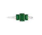 Elegant emerald and white zircon ring in sterling silver with brilliant green gemstone and shimmering halo design
