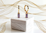 Gold hoops earrings featuring baguette-cut purple amethyst stone

