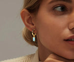 Load image into Gallery viewer, 18K yellow gold-plated huggie earrings with 8x4mm baguette cut Ocean Topaz.
