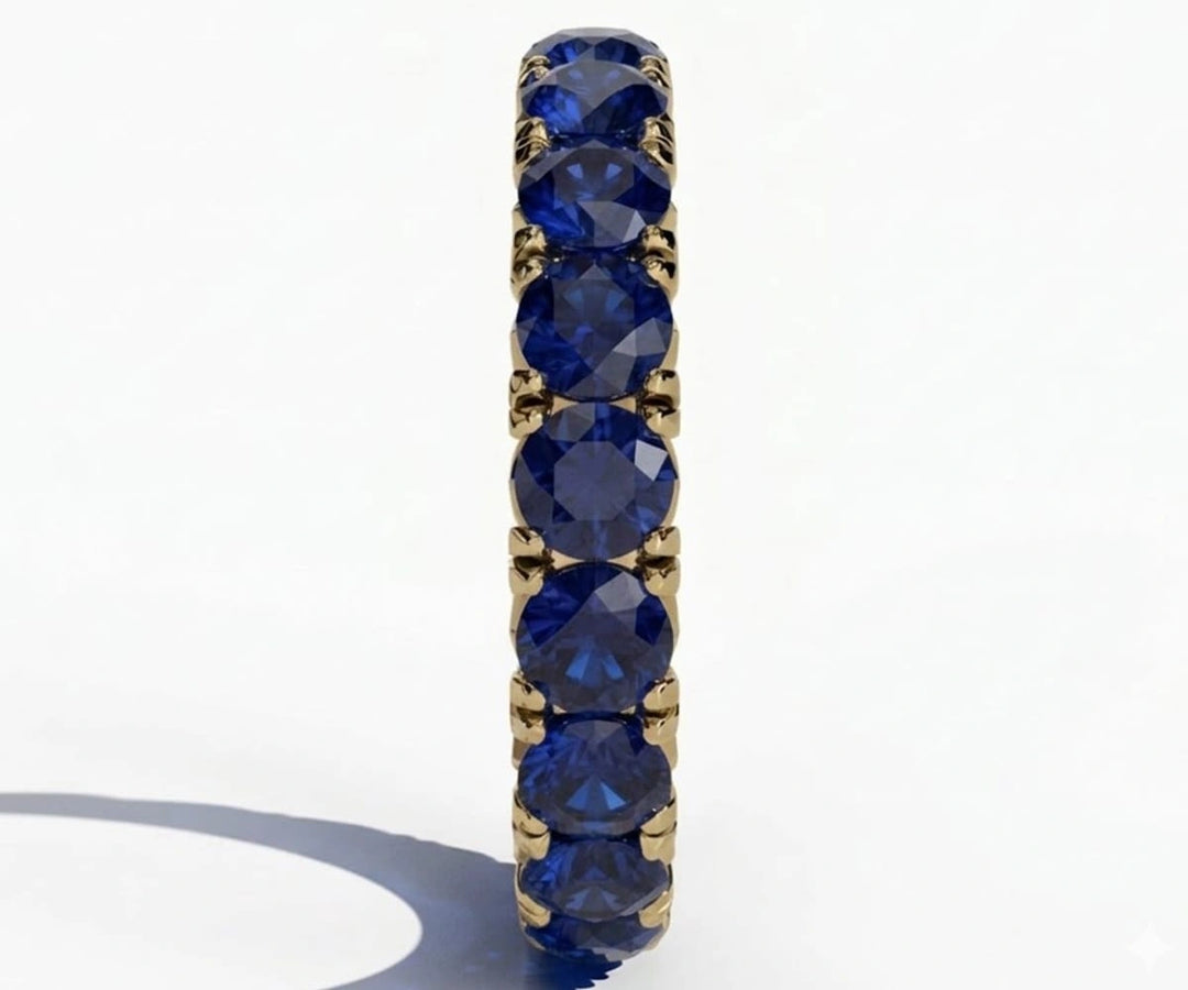 Elegant blue sapphire eternity band featuring round cut stones encircling the ring for a timeless and luxurious look
