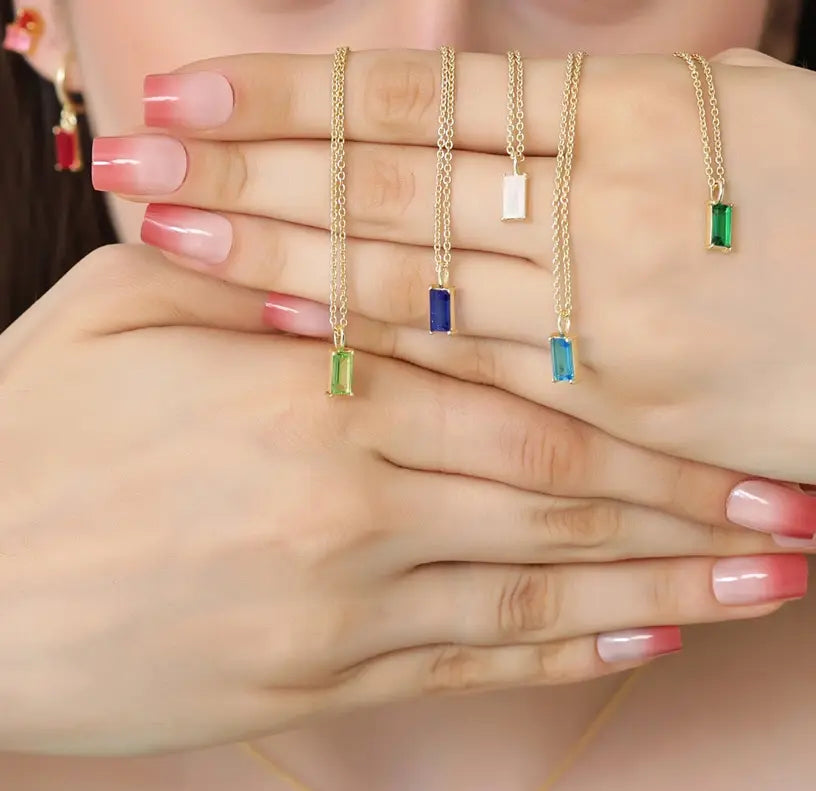 Delicate birthstone necklaces featuring a sparkling gemstone set in a minimalist pendant.