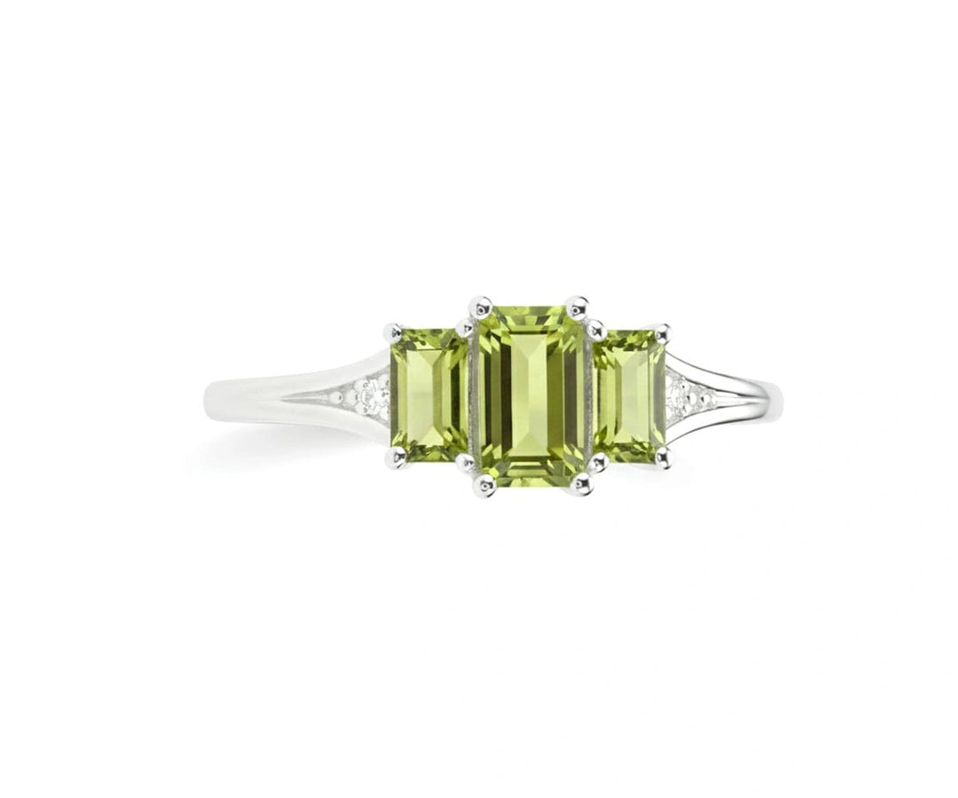 Oval peridot ring with white zircon accents set in sterling silver band offering fresh green brilliance and delicate sparkle