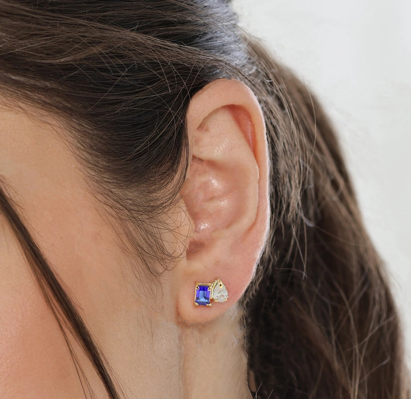 Close-up of Toi et Moi stud earrings featuring contrasting stones in a sleek gold setting

