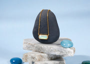 Close-up of ocean topaz stone on elegant gold chain