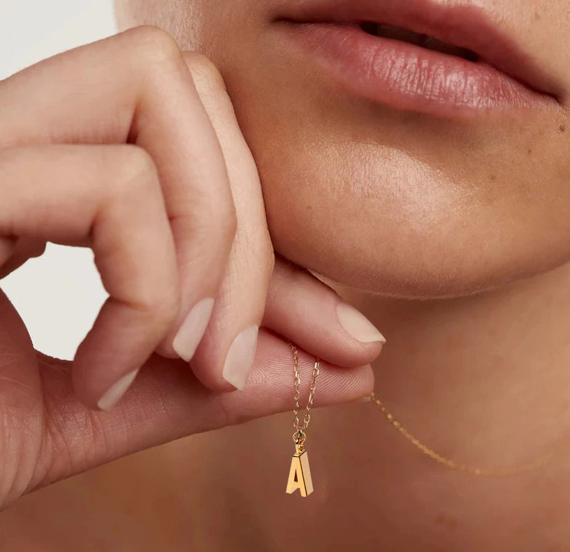 Chic and delicate gold initial A necklace resting on a smooth anchor chain, designed for layering or wearing solo with a touch of personal flair.