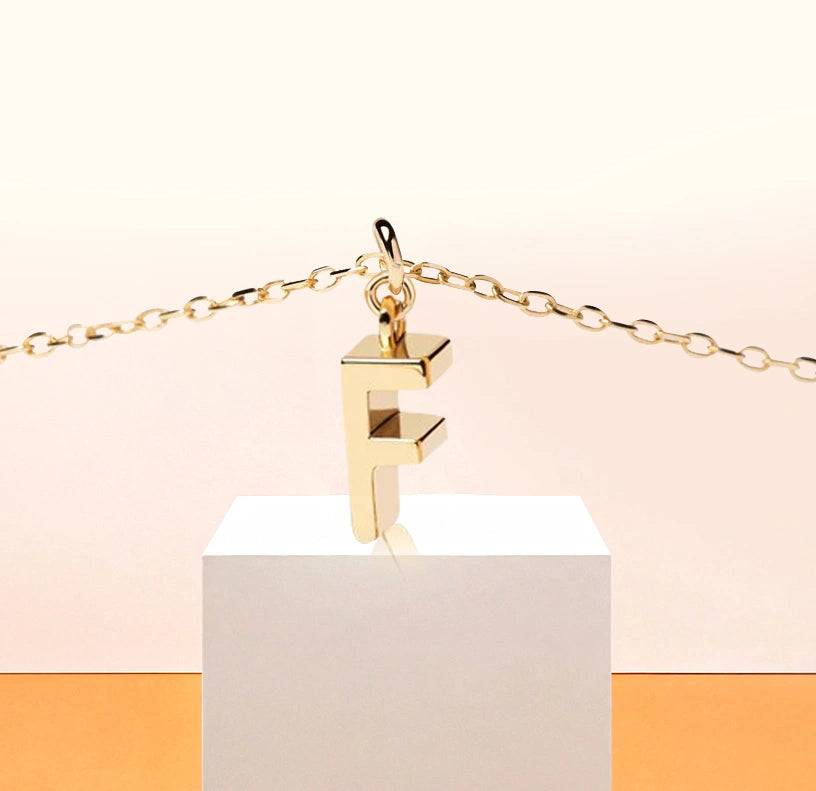 Slim and stylish initial "F" pendant necklace, adding a personal glow to any neckline.