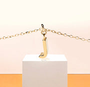 Chic dainty necklace with a gold letter J pendant, capturing understated sparkle on an adjustable anchor chain with a secure clasp.