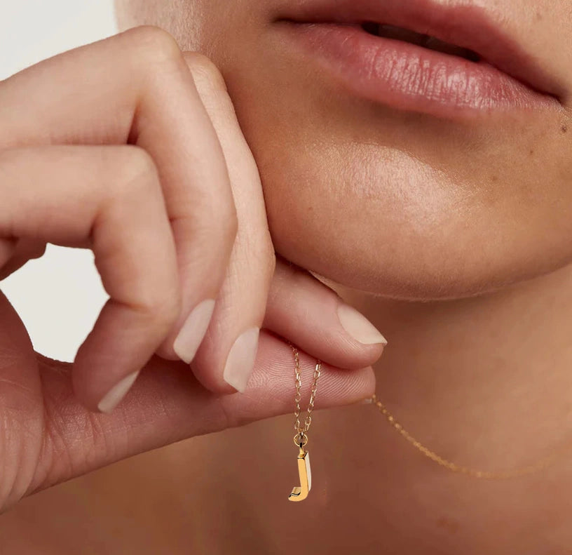 Gold dainty necklace with the letter J pendant, gracefully suspended from a sleek adjustable anchor chain for a touch of personalized shine.