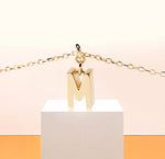 Load image into Gallery viewer, Minimalist initial M necklace in gold, a lightweight and personal accessory set on a fine anchor chain for effortless daily sophistication.

