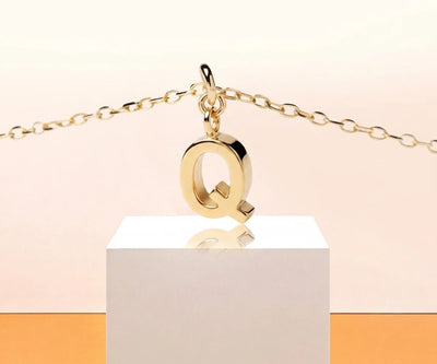 Dainty initial Q necklace in gold with minimalist pendant on a delicate chain