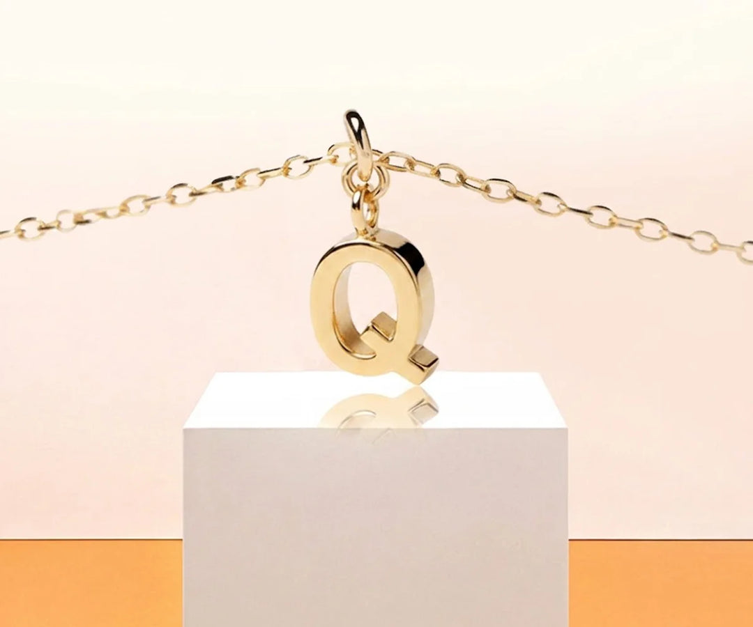 Dainty initial Q necklace in gold with minimalist pendant on a delicate chain