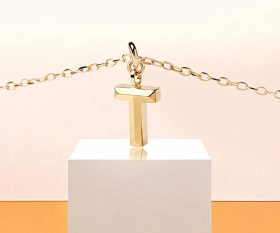 Dainty letter T necklace in gold with minimalist initial pendant on a fine chain for everyday wear