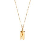Personalized dainty “N” charm necklace in warm gold tones, adding a soft glow to your neckline.


