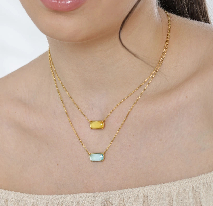A delicate birthstone charm necklace featuring a small, colorful gemstone charm that adds a personal and elegant touch to everyday style.