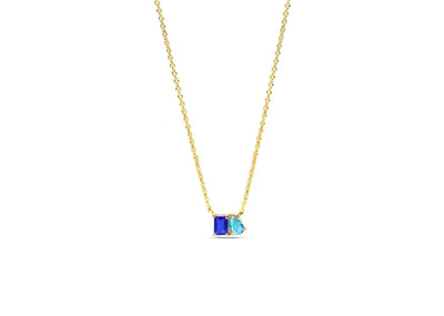 Toi et Moi necklace close-up showing emerald-cut blue sapphire and pear-cut ocean topaz pendant on 18K gold plated chain — December birthstone jewelry for women