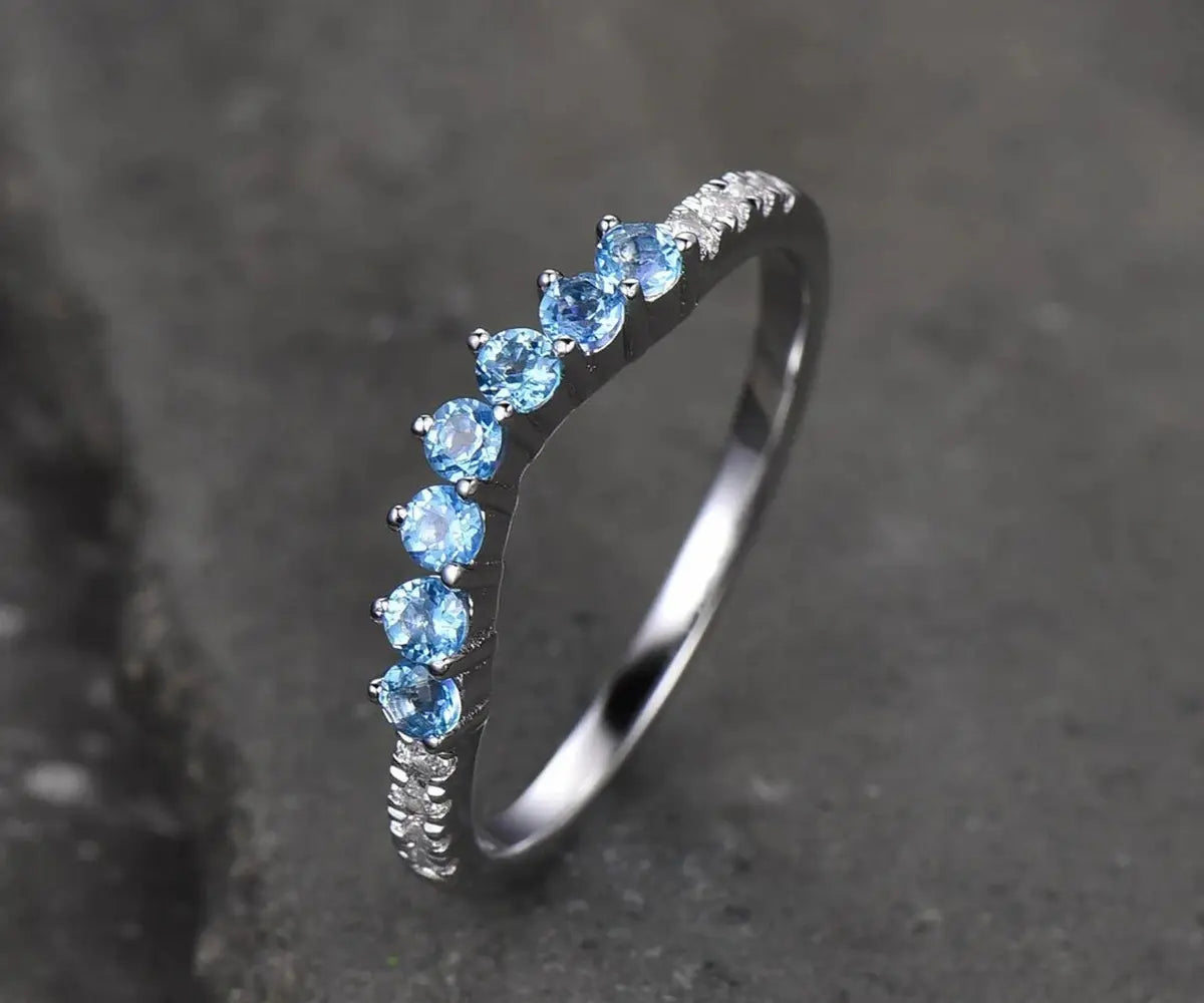 Sterling silver wedding band with soft blue topaz and sparkling zircon, perfect for stacking or solo wear.