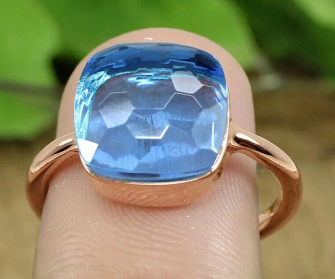 Minimal blue topaz ring in a stackable design featuring a dainty faceted gemstone in silver finish
