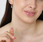 December birthstone necklace with shimmering blue topaz pendant on a delicate gold chain.

