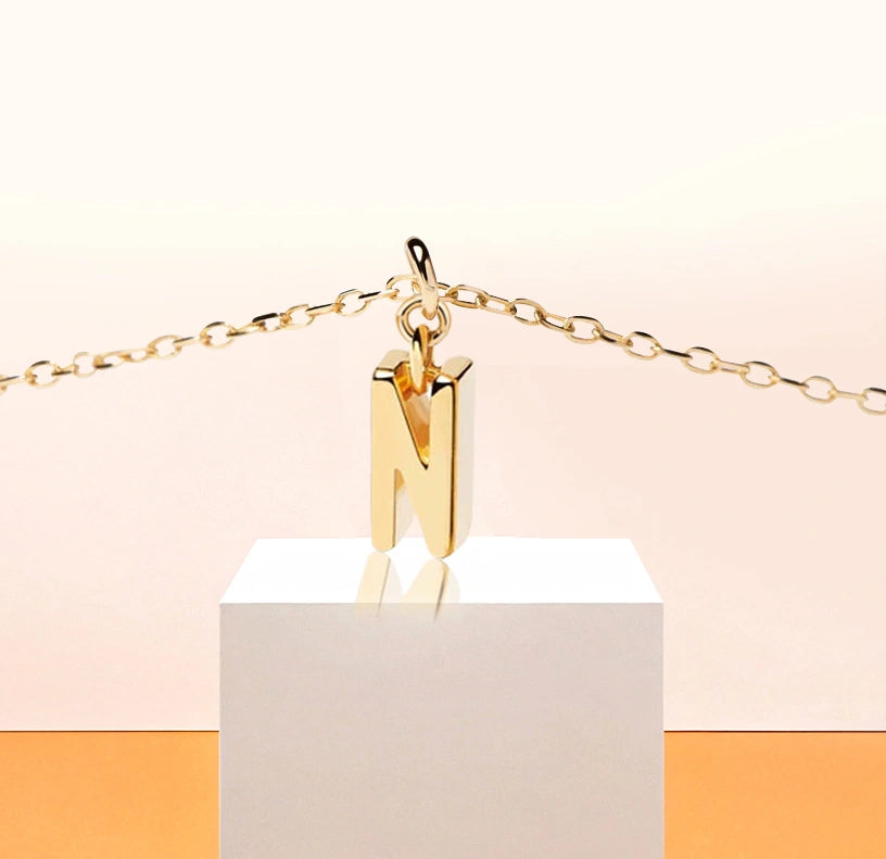 Fine gold necklace showcasing the letter “N”, a delicate piece to mark your signature look.