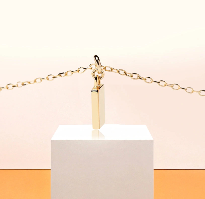 Elegant gold-plated "I" initial necklace with a sleek, minimalist design on a delicate anchor chain.