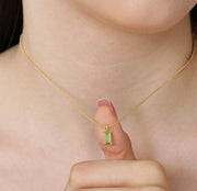 August birthstone necklace featuring a vibrant green peridot pendant on a gold chain.
