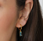 Blue topaz hoop earrings for December birthstone, set in gold with a radiant shine.