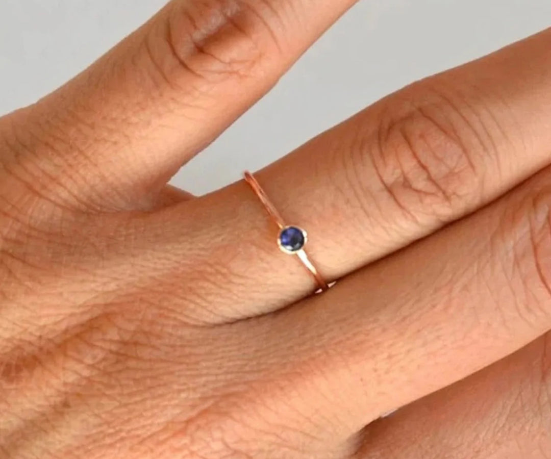 Vintage style blue sapphire engagement ring with intricate detailing and deep blue gemstone