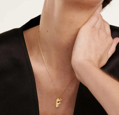 Refined gold "F" initial pendant on a minimalist chain, the perfect touch of personal style.