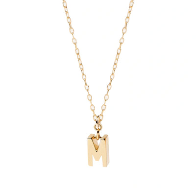Petite gold initial M pendant hanging from an anchor chain, designed for subtle shimmer and perfect for layering with other delicate pieces.