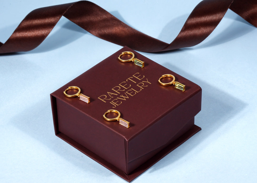 Charm hoop earrings featuring delicate hanging charms on sleek hoops, creating a playful yet elegant jewelry style.