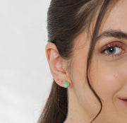 Elegant chrysoprase stud earrings featuring vibrant green gemstones in a classic gold setting.

