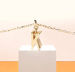 Elegant initial K necklace in 18K gold-plated brass with a 9mm x 3mm pendant, designed for timeless, personalized style.
