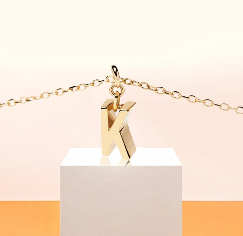 Elegant initial K necklace in 18K gold-plated brass with a 9mm x 3mm pendant, designed for timeless, personalized style.