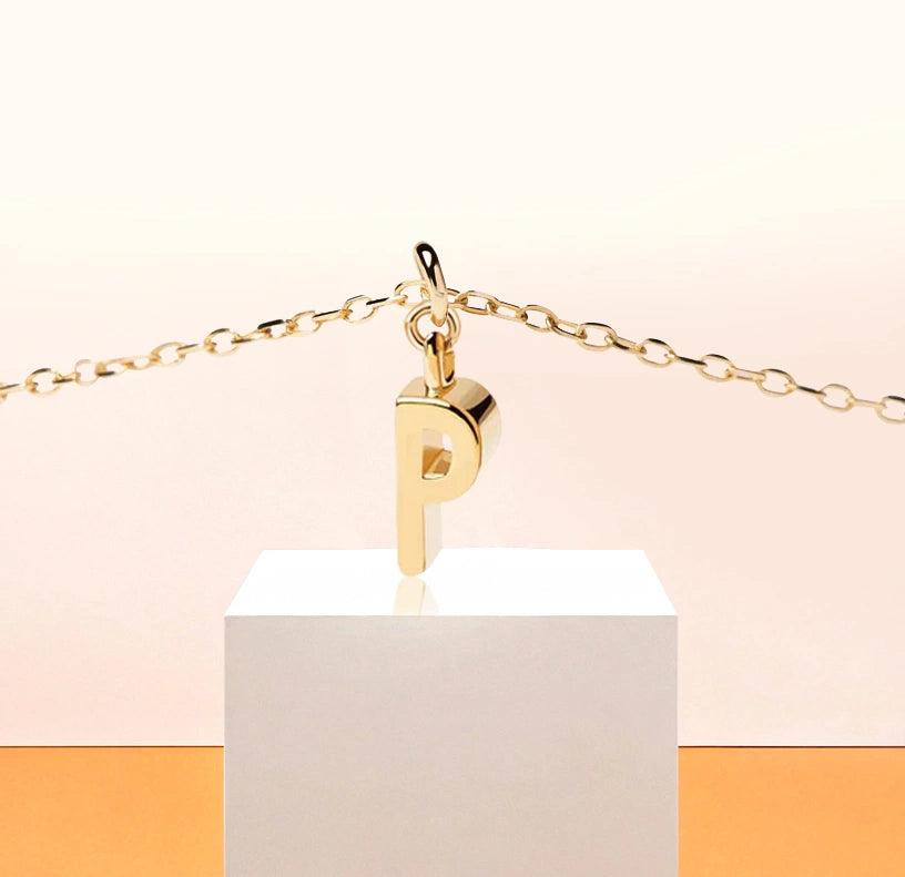 Delicate initial "P" charm necklace, adding a refined golden shimmer to any outfit.
