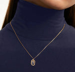 A gold initial pendant featuring a shiny letter charm on a delicate gold chain, adding a personalized and elegant touch to any outfit.

