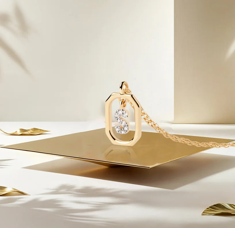 A gold necklace initial pendant featuring a polished letter charm on a delicate chain, adding a personalized and elegant touch to any outfit.