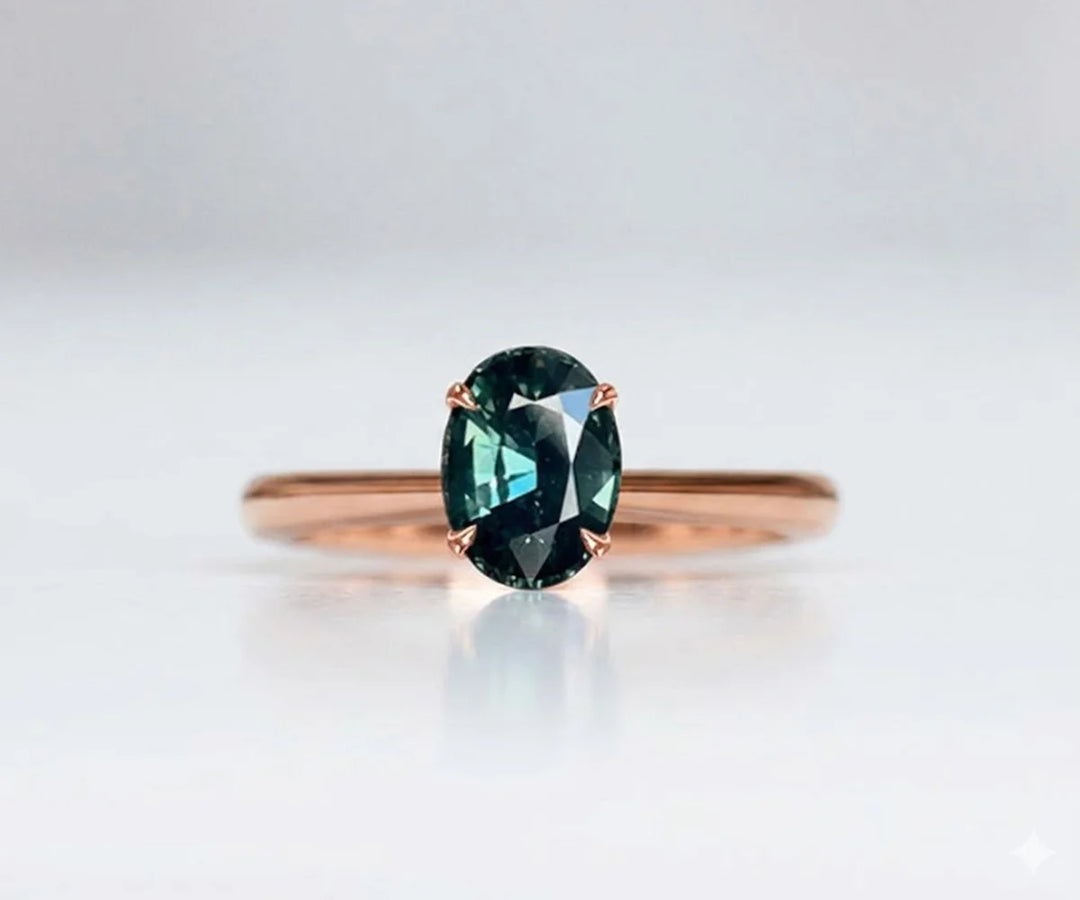 Teal sapphire engagement ring with elegant oval gemstone and diamond accents in gold setting