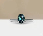 Teal sapphire solitaire engagement ring in minimalist gold band for modern bridal look
