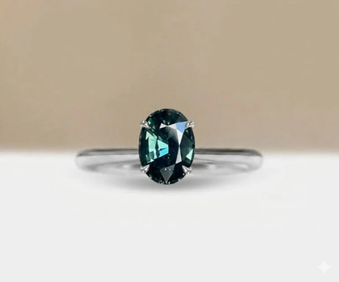 Teal sapphire solitaire engagement ring in minimalist gold band for modern bridal look