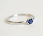Cushion cut blue sapphire engagement ring with side diamonds in a classic setting
