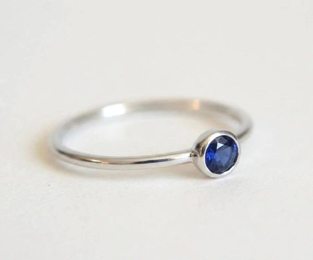 Cushion cut blue sapphire engagement ring with side diamonds in a classic setting